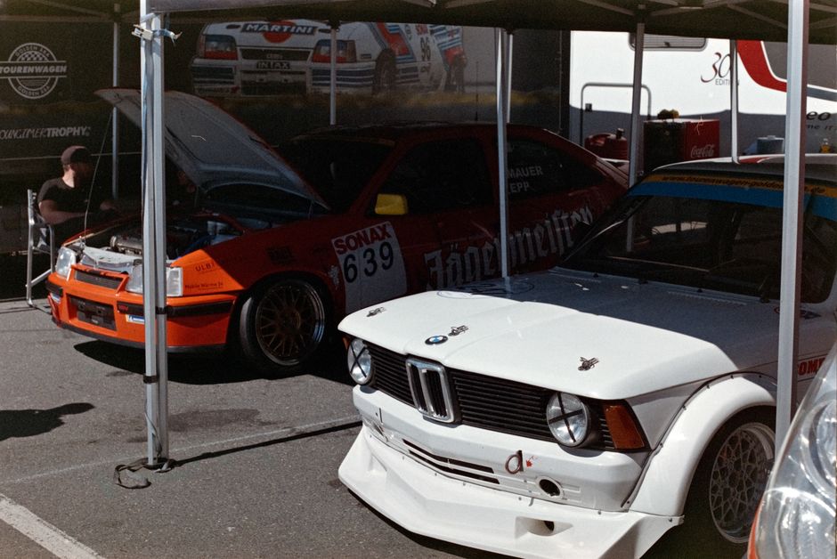 Vintage racing cars on display at a motorsport event, showcasing classic automotive design.