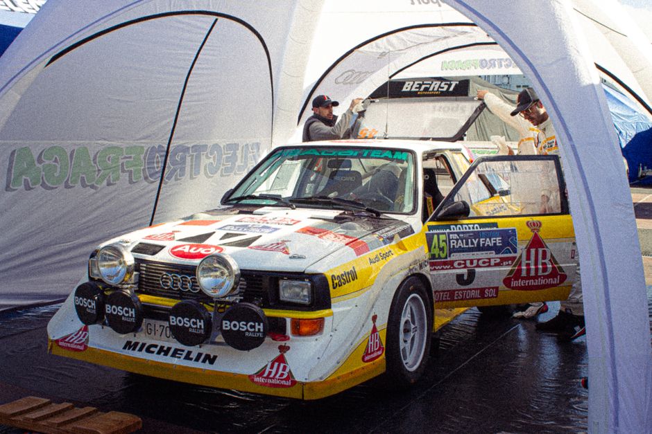 Vintage Audi Quattro rally car showcased at a Portugal racing event with authentic 80s feels.